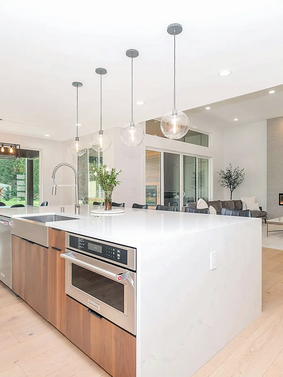 Cocina abierta con isla blanca y suelo de madera