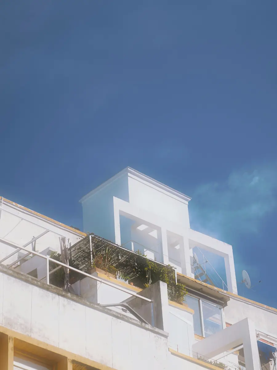 Fachada blanca de vivienda moderna bajo cielo azul